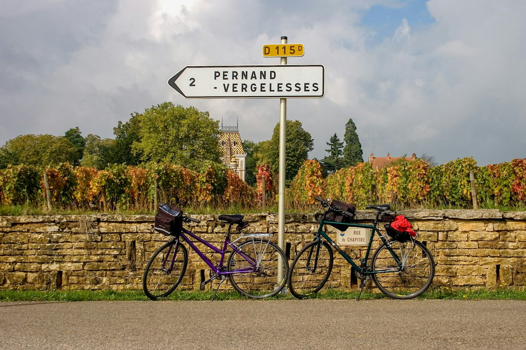 Bicycles by a vineyard wall beneath a road sign to Pernand-Vergelesses near Beaune, Burgundy