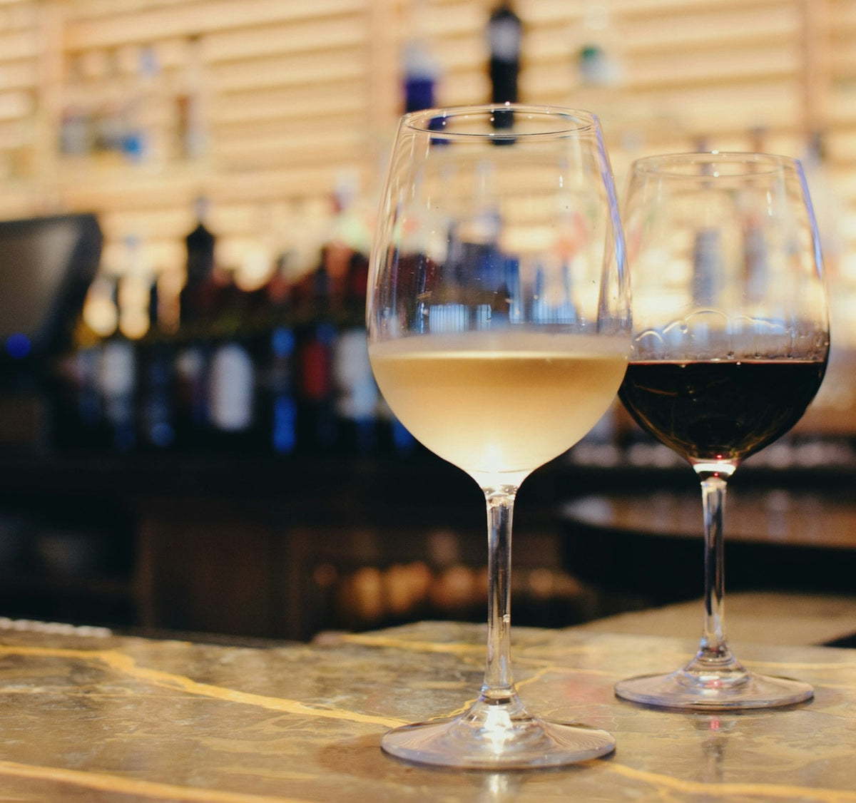Glasses of white and red wine on a wine bar counter