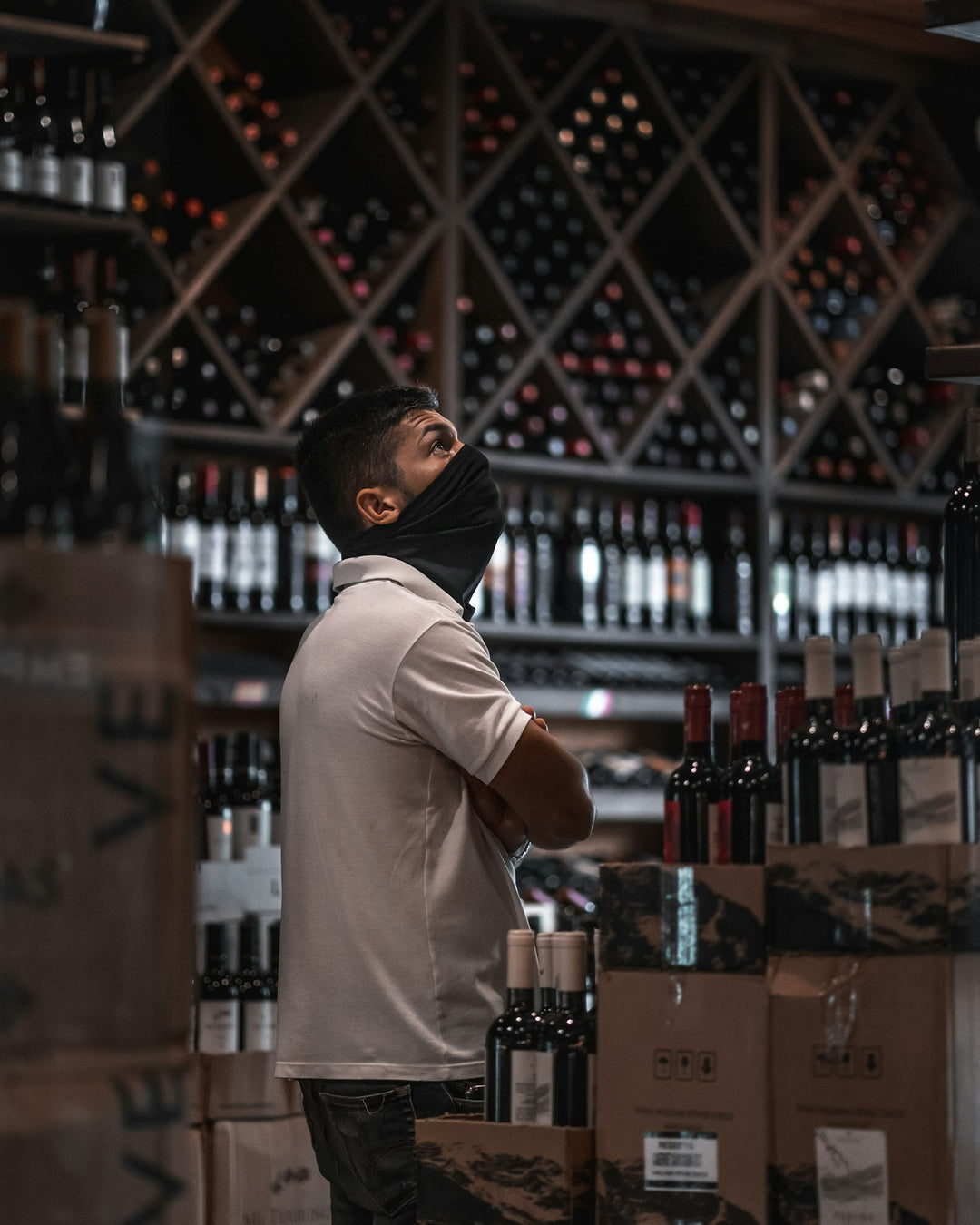 A shopper browsing bottles on the shelves of a wine shop