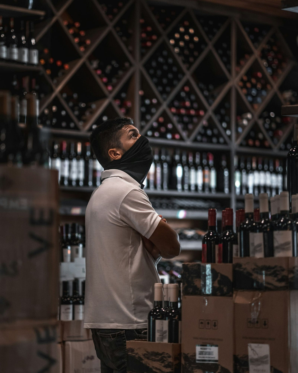 A shopper browsing bottles on the shelves of a wine shop