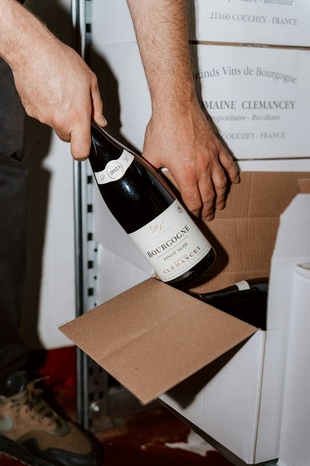 A bottle of wine being packed into a shipping box