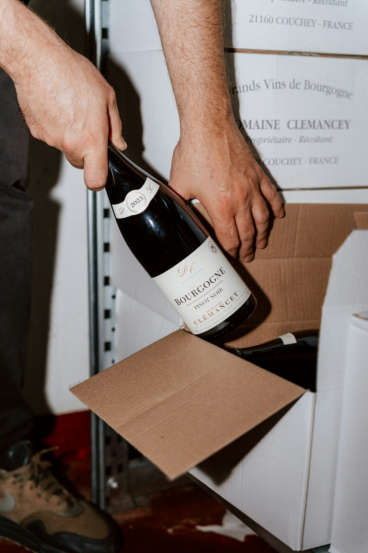A bottle of wine being packed into a shipping box