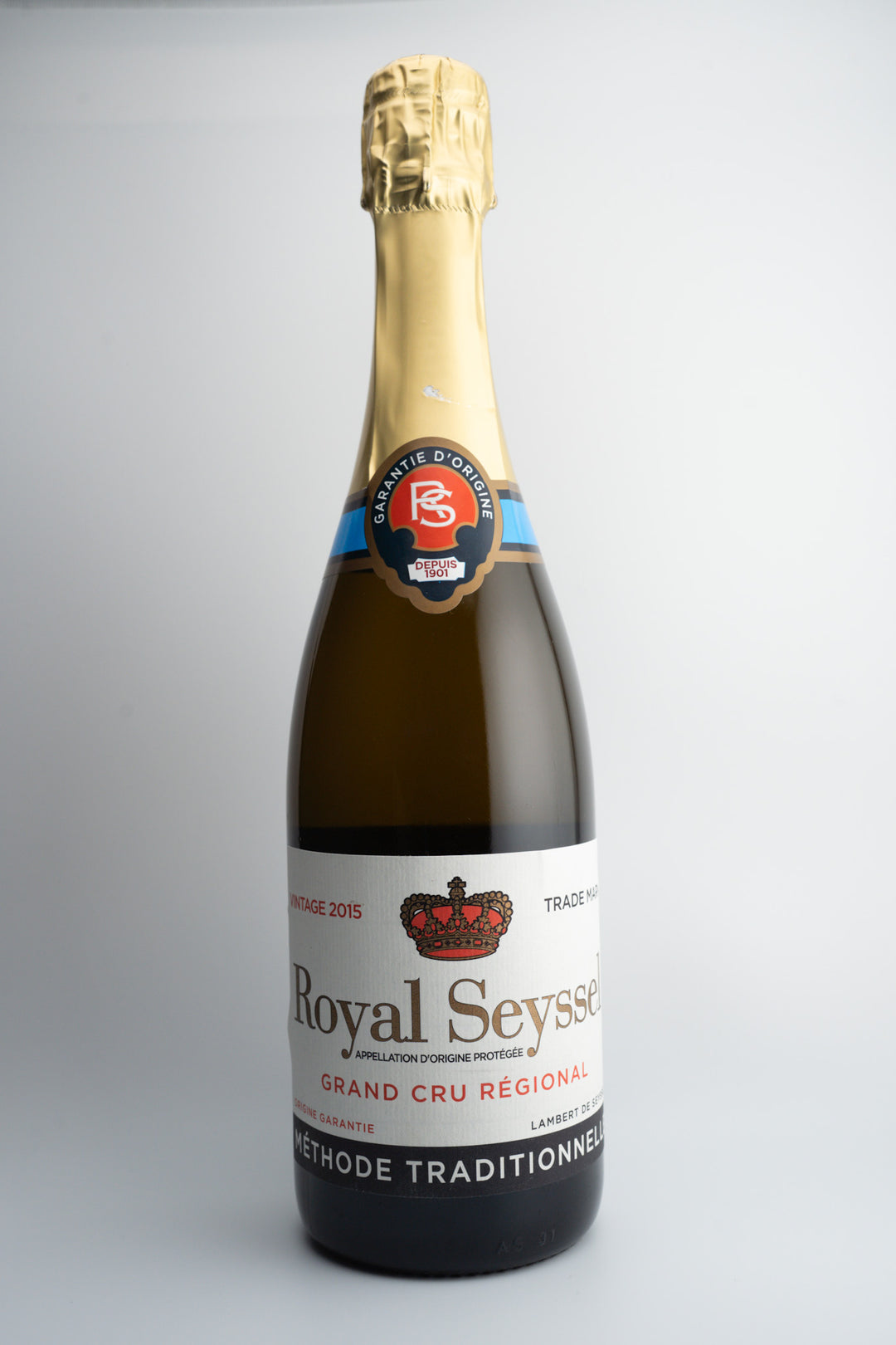 A bottle of 2015 Lambert de Seyssel Grand Cru Royal Brut sparkling wine with a gold foil cover on top and a label that includes the brand name and region.