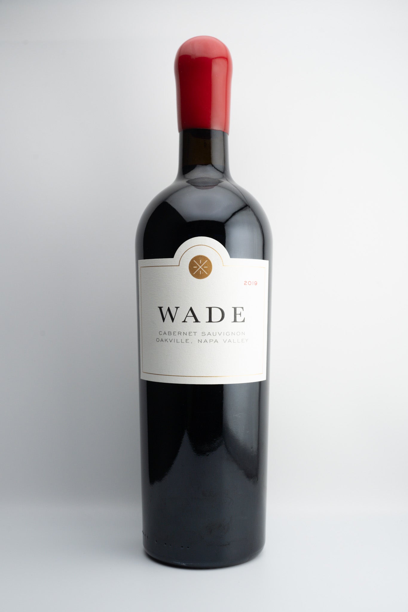 A bottle of 2019 Wade Cellars Cabernet Sauvignon with a dark label and a red cap, set against a white background.