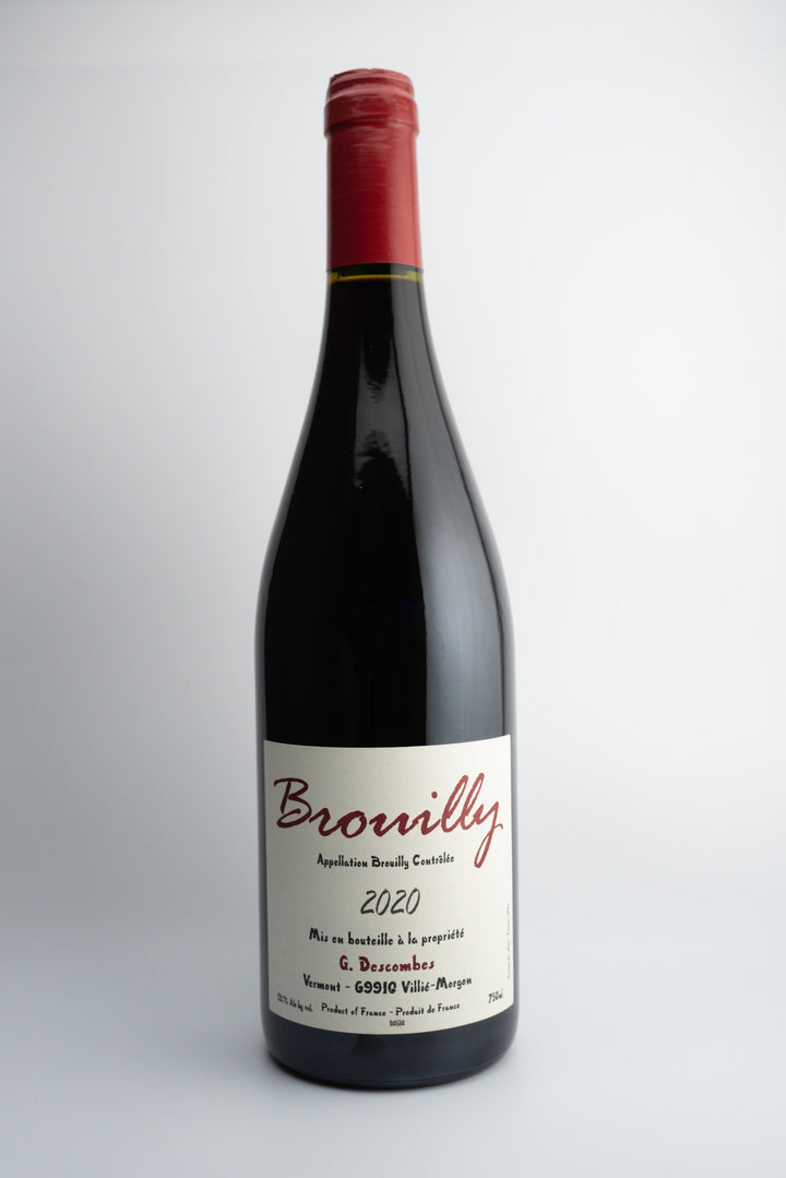 A bottle of 2020 Georges Descombes Brouilly wine with a red label, organically farmed, from Beaujolais, France.
