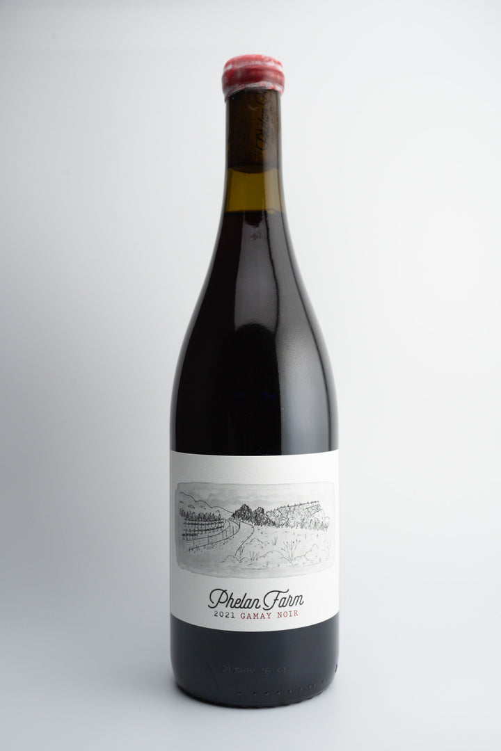 A bottle of 2021 Phelan Farms Gamay Noir wine with a label that includes the brand name and the word &