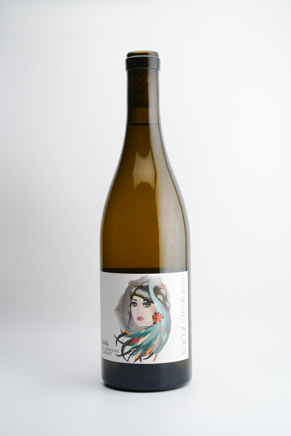 A bottle of 2022 Social Creatures 'Mara' Chenin Blanc wine with a label featuring an illustration of a woman's face.
