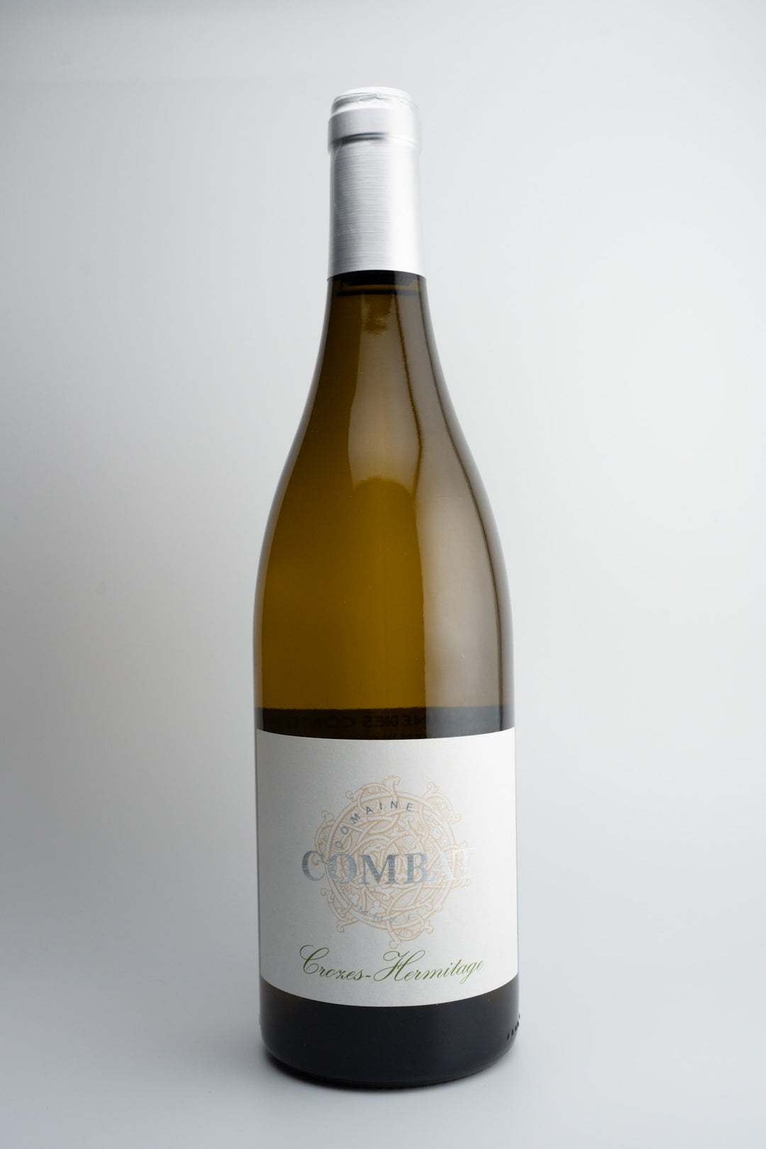 A bottle of Domaine des Combat Crozes-Hermitage Blanc wine with a white label, from the Northern Rhône Valley, France.