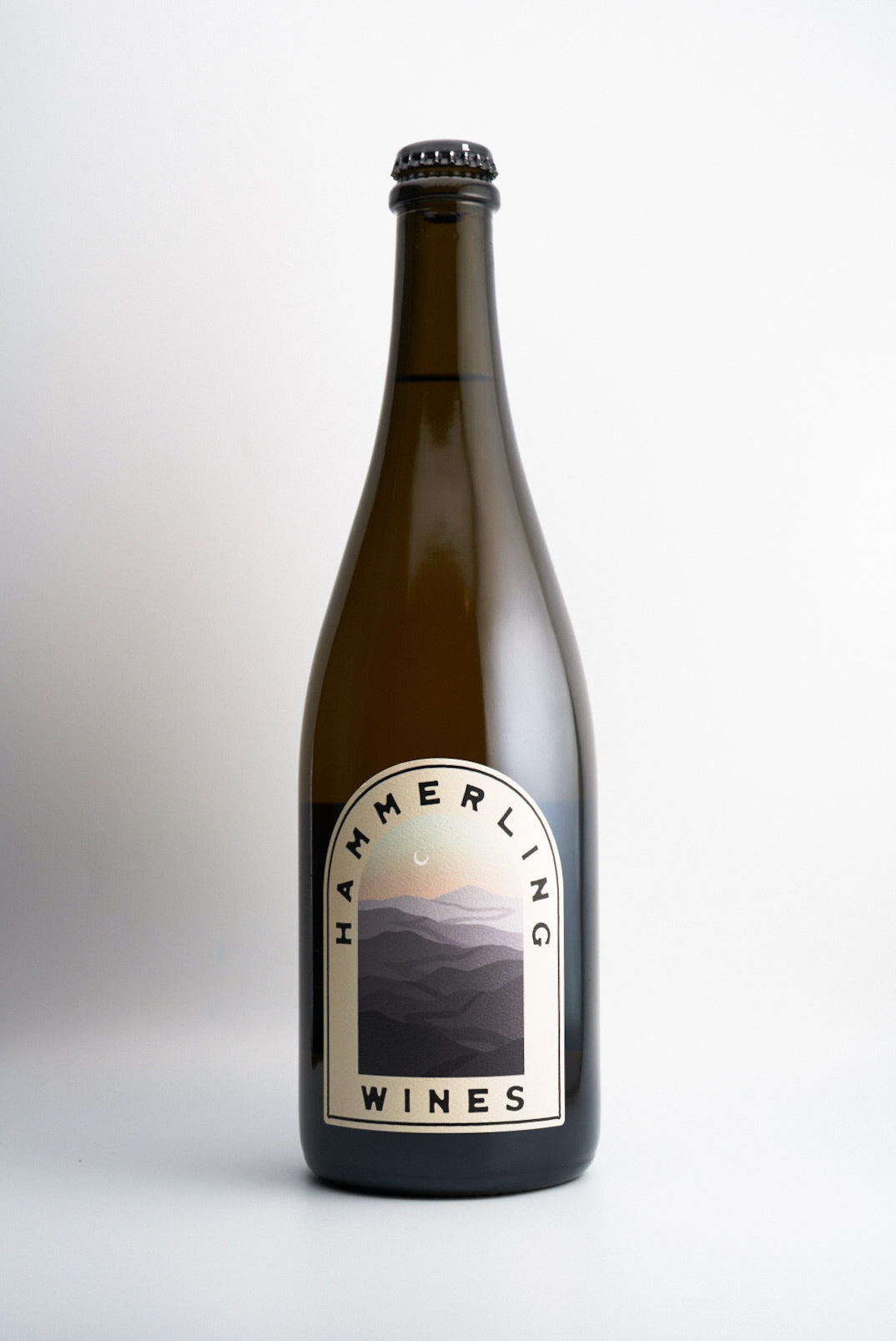 A bottle of Hammerling Wines 'Tilted Mile' Sparkling Wine with a label featuring a mountain range.