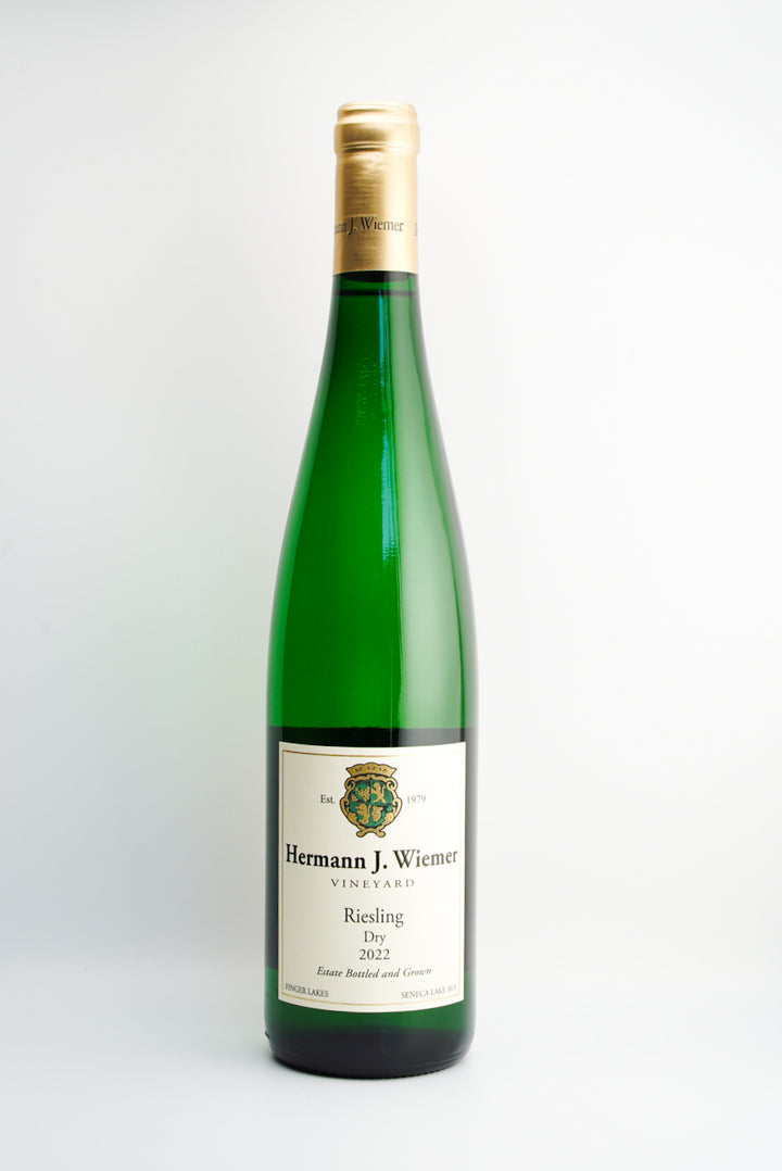 A bottle of Hermann J. Wiemer Dry Riesling wine with a label indicating it is from Seneca Lake AVA, Finger Lakes, New York.