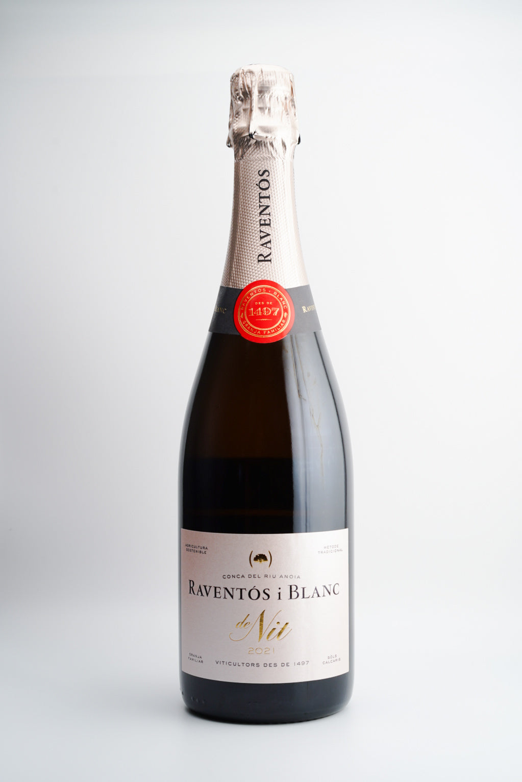 A bottle of Raventós i Blanc 'De Nit' Extra Brut Rosé sparkling wine with a red capsule and label, against a white background.