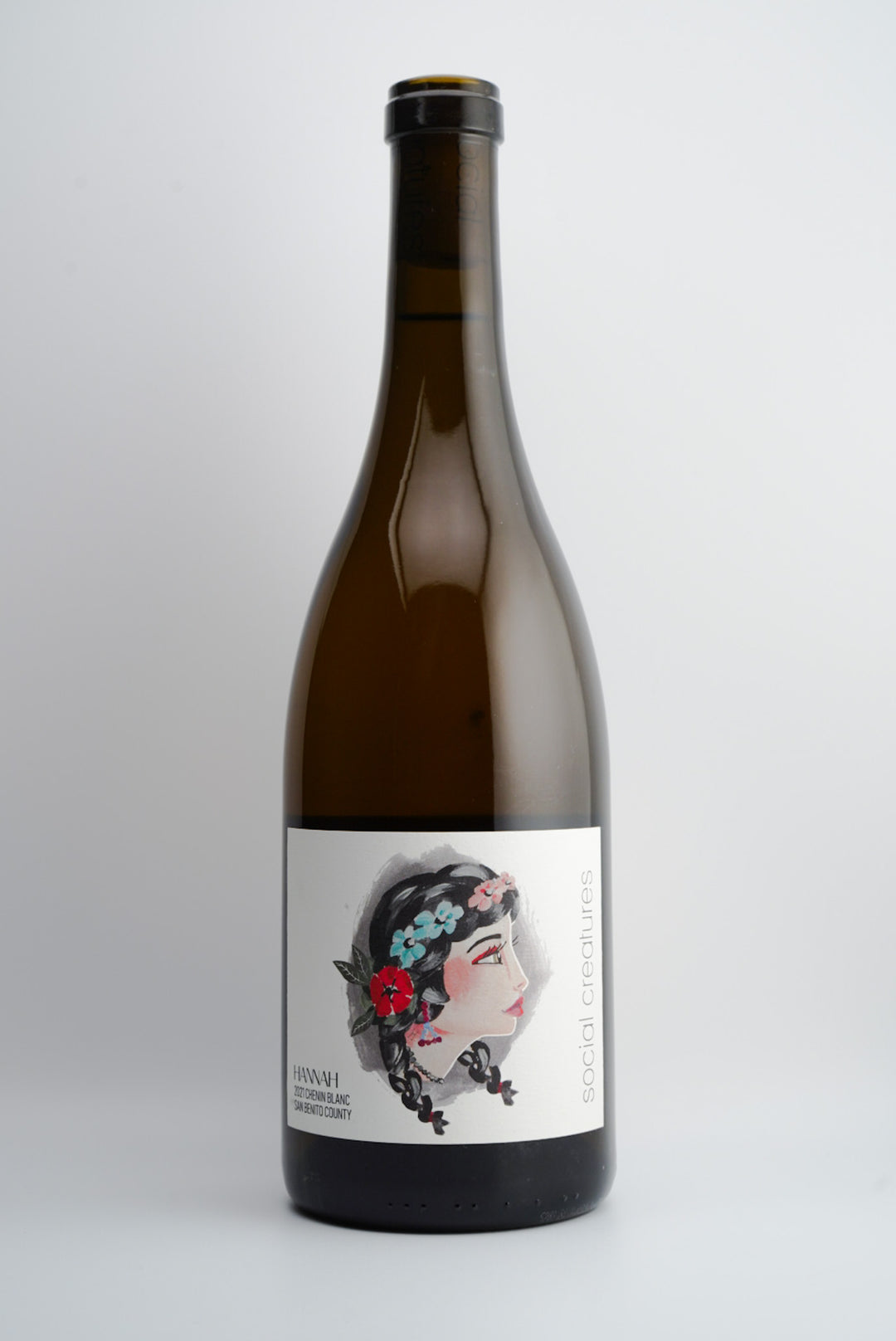 A bottle of Social Creatures 'Hannah' Chenin Blanc wine with a label featuring an illustration of a woman's face with flowers in her hair.