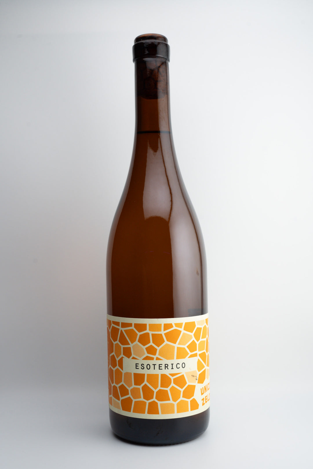 A bottle of Unico Zelo Esoterico Orange Wine with a yellow label, indicating the grape variety and wine type.