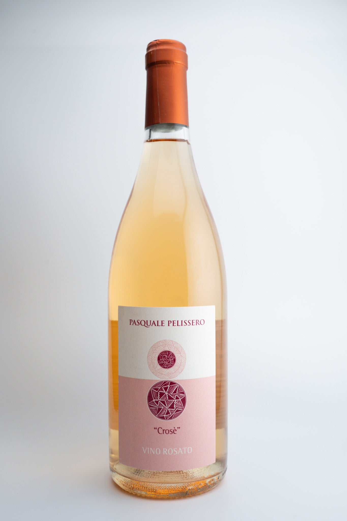 A bottle of Pasquale Pelissero 'Crosè' Rosato wine with a pink label and a red cap, indicating it is a light pink wine from Piedmont, Italy.