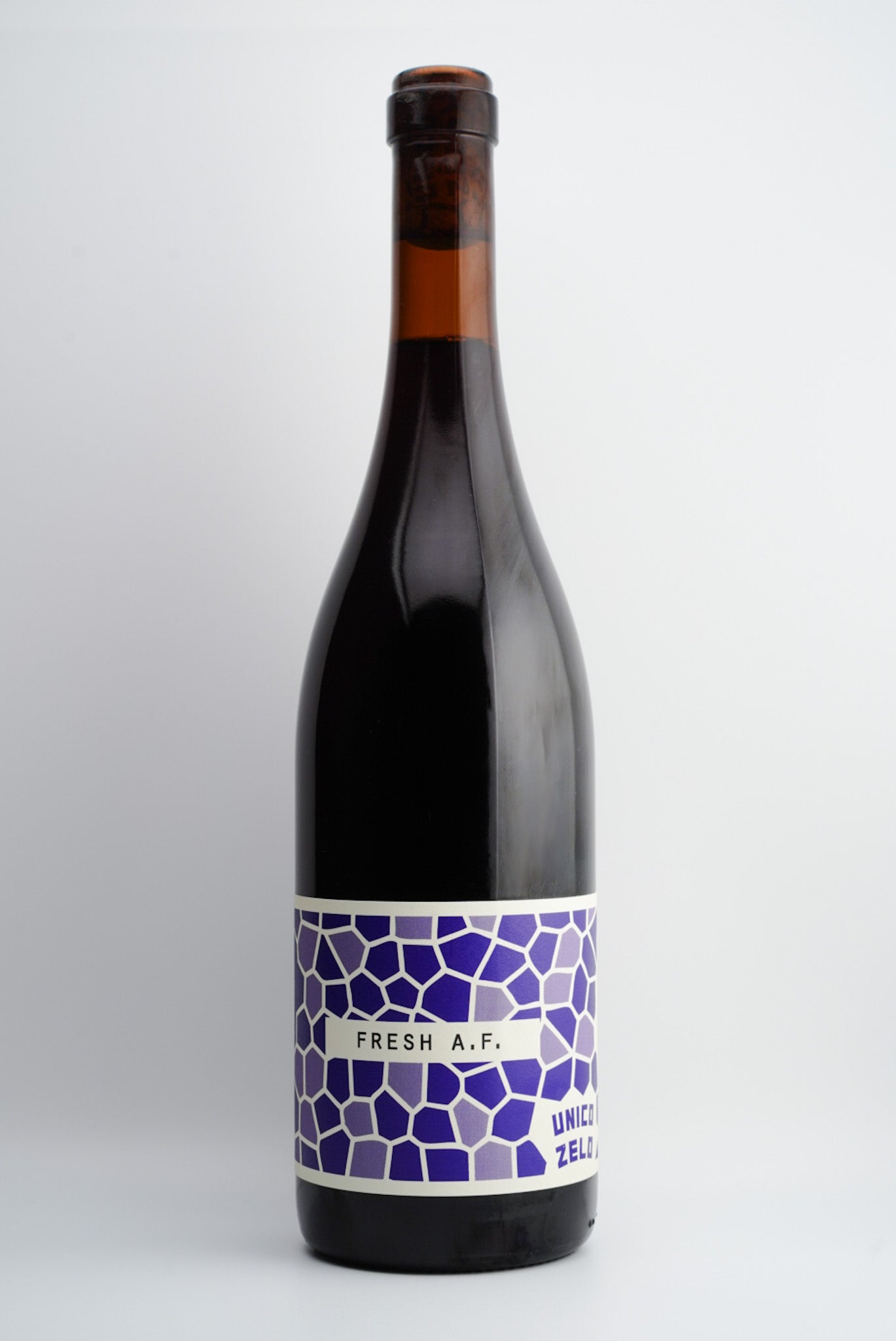 A bottle of Unico Zelo Fresh A.F. Nero d'Avola wine with a purple label on a white background.